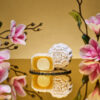 Mini Champagne Truffle Snowskin mooncake by JU Signatures, whole and halved showing golden white lotus paste with a pale truffle centre