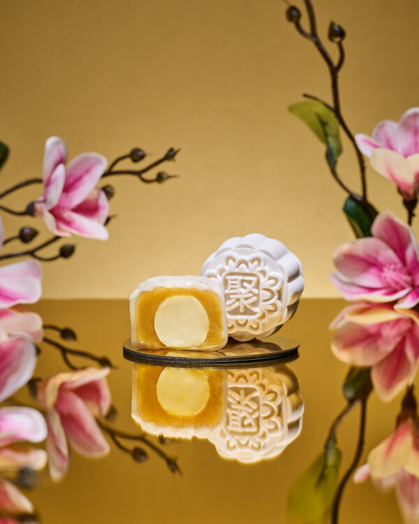Mini Champagne Truffle Snowskin mooncake by JU Signatures, whole and halved showing golden white lotus paste with a pale truffle centre