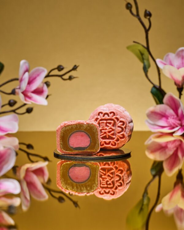 Mini Lychee Martini Snowskin mooncake by JU Signatures, whole and halved showing red wine and cranberry paste with a pink lychee martini centre