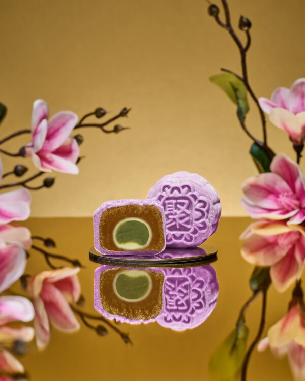 Mini Muscat Grape Sencha Snowskin mooncake by JU Signatures, whole and halved showing white lotus paste with a green sencha centre