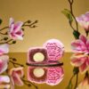 Mini Raspberry Rose Snowskin mooncake by JU Signatures, whole and halved showing white lotus paste with a pale centre.