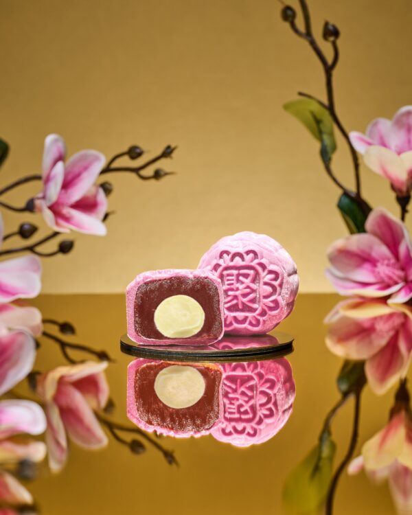 Mini Raspberry Rose Snowskin mooncake by JU Signatures, whole and halved showing white lotus paste with a pale centre.